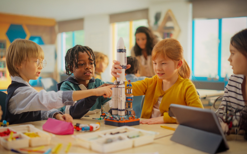 Diverse K-12 students using tablets for STEM eLearning in a modern, inclusive classroom.